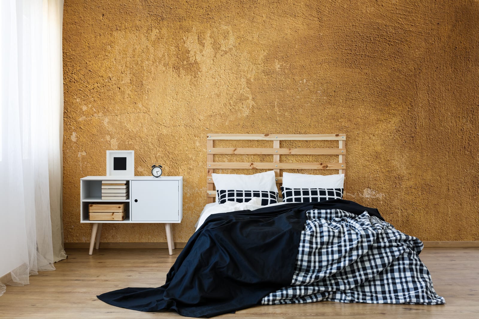 Statement ochre textured accent wall enhancing cozy bedroom with earthy rustic tones